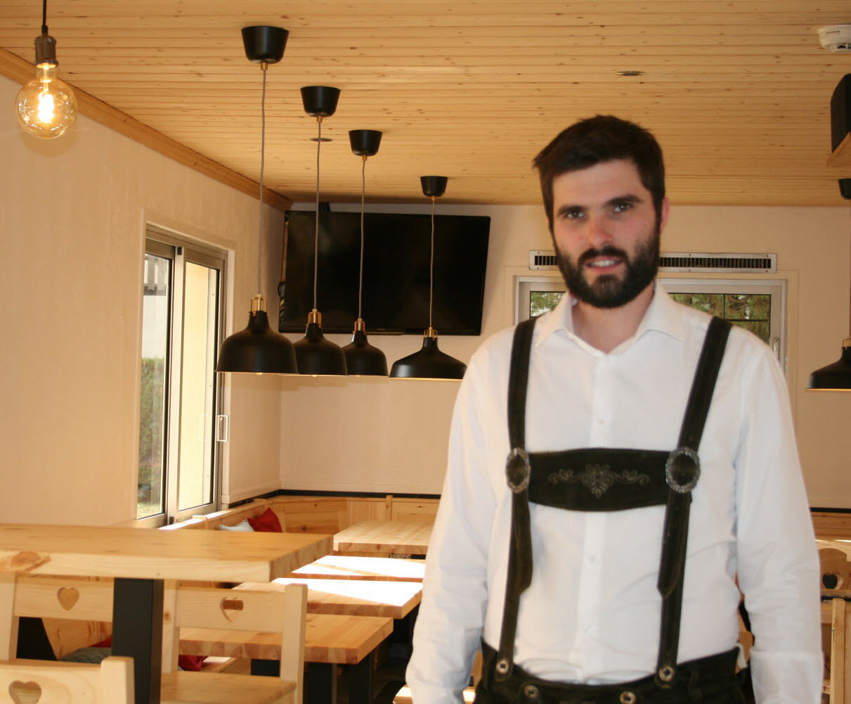 Thibaud Euler dans la salle d'Au Bavarois à l'ouverture en octobre 2018, en lederhose à bretelles et chemise blanche.